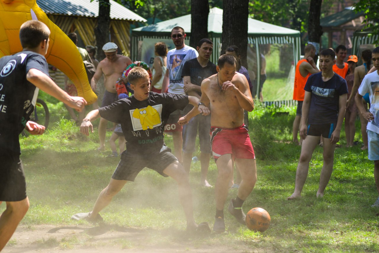 Мужчины играют в футбол в лесу